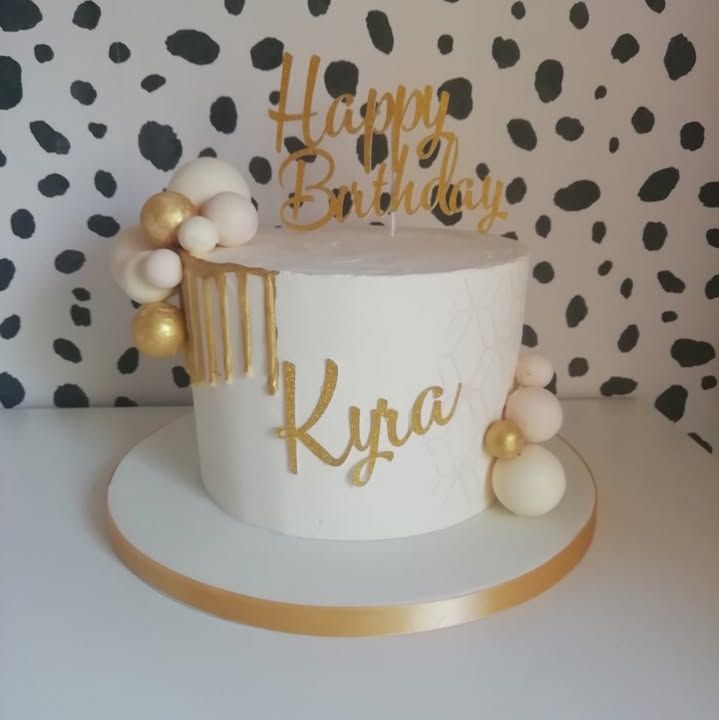 White and gold birthday cake with a gold drip and name